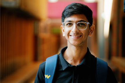 Male student standing outside happy