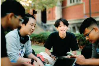 Student sitting outside happy smiling